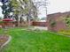 Serene backyard featuring a well-maintained lawn, patio area, privacy fence, and mature trees at 1315 Grape St, Denver, CO 80220