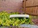 Secluded stone bench situated amongst green shrubs in a brick-walled yard at 1315 Grape St, Denver, CO 80220