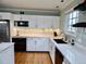 Bright kitchen with white cabinets, granite countertops, stainless steel appliances, and hardwood floors at 1315 Grape St, Denver, CO 80220