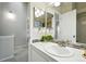 Well-lit bathroom with vanity, large mirror, and mosaic backsplash at 1978 Newland Ct, Lakewood, CO 80214