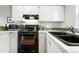 Well-lit kitchen featuring modern appliances, white cabinets, and a sleek countertop at 1978 Newland Ct, Lakewood, CO 80214
