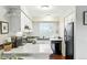 Bright kitchen with white cabinets, modern appliances, and a view of the backyard from the window at 1978 Newland Ct, Lakewood, CO 80214