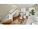 Cozy living room area features hardwood floors, neutral decor, staircase, and entry to kitchen at 1978 Newland Ct, Lakewood, CO 80214