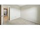 Empty carpeted room with neutral walls, leading to an adjacent area with a washer and dryer at 1978 Newland Ct, Lakewood, CO 80214