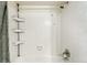 Clean white tiled shower with shower head and a storage rack at 1978 Newland Ct, Lakewood, CO 80214