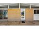 Covered back patio with brick siding, a white door, and views of the backyard at 1573 S Dexter Way, Denver, CO 80222