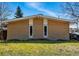 Tan brick house with a low-pitched roof and two tall, narrow windows at 1573 S Dexter Way, Denver, CO 80222
