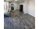 Open-concept living area with wood-look flooring and a view of the modern, white kitchen at 3241 E 84Th Dr, Thornton, CO 80229