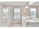 Bathroom featuring a glass enclosed shower, double sink vanity, and tile floors at 840 Leeward St, Lochbuie, CO 80603