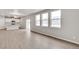 Open-concept living space with hardwood floors and large windows showcasing the backyard at 840 Leeward St, Lochbuie, CO 80603