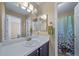 Bathroom featuring a large mirror, single sink vanity, and a shower with leaf pattern curtain at 5189 S Malta Way, Centennial, CO 80015