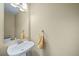 Small half bathroom features pedestal sink and mirror in neutral tones at 5189 S Malta Way, Centennial, CO 80015