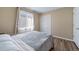 Well-lit bedroom featuring hardwood floors, a window with curtains, and a sliding door closet at 5189 S Malta Way, Centennial, CO 80015
