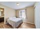 Bright bedroom showcasing hardwood floors, a sunlit window with curtains, and ensuite bathroom at 5189 S Malta Way, Centennial, CO 80015