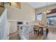 Cozy dining area with warm lighting, wood floors, an adjoining staircase, and a view of the fireplace at 5189 S Malta Way, Centennial, CO 80015
