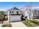 Attractive exterior of home with green lawn, a spacious driveway, and a white garage door at 5189 S Malta Way, Centennial, CO 80015