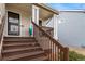 A charming front porch with steps leading up to the entrance and a comfortable seating area at 5189 S Malta Way, Centennial, CO 80015