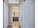 Hallway with hardwood floors, sliding door closet, and an open view to a full bathroom with double vanity sinks at 5189 S Malta Way, Centennial, CO 80015