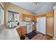 Bright kitchen boasts wooden cabinets, white appliances, and natural light from a window at 5189 S Malta Way, Centennial, CO 80015
