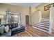 Inviting living room with modern floors, plenty of light, and a comfortable seating area near the stairs at 5189 S Malta Way, Centennial, CO 80015