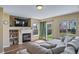 Living room with fireplace, large TV, and a sliding glass door to the backyard at 5189 S Malta Way, Centennial, CO 80015