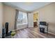 Bright room with hardwood floors, a window with curtains, and an open doorway to a bathroom at 5189 S Malta Way, Centennial, CO 80015