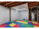 Utility area in basement including washer/dryer hookups and water heater with colorful foam flooring at 6711 S Race St, Centennial, CO 80122