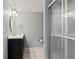This bathroom features a tiled shower, black vanity and light grey walls at 6711 S Race St, Centennial, CO 80122