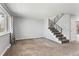 Open living room with a staircase, large window, and neutral carpeting at 6711 S Race St, Centennial, CO 80122