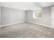 A finished basement with gray walls and neutral carpet, brightened by a window with blinds at 5324 S Malta Way, Centennial, CO 80015