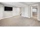 Large finished basement with neutral carpeting, closet, and a mounted flat-screen television at 5324 S Malta Way, Centennial, CO 80015