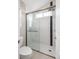 Glass enclosed shower with a blue tile detail, next to the toilet and a hand towel bar at 5324 S Malta Way, Centennial, CO 80015