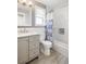 Updated bathroom with a gray vanity, a white toilet, and a shower with a patterned curtain at 5324 S Malta Way, Centennial, CO 80015