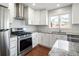 Contemporary kitchen featuring stainless steel appliances, granite countertops, a tiled backsplash, and ample cabinet space at 5324 S Malta Way, Centennial, CO 80015