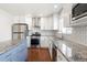 Well-equipped kitchen featuring stainless steel appliances, granite countertops, a stylish backsplash, and wood flooring at 5324 S Malta Way, Centennial, CO 80015