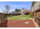 The backyard features a green lawn, mature landscaping, and a cozy deck area at 10436 W 84Th Pl, Arvada, CO 80005