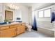 Bathroom featuring a vanity with a single sink, a toilet, and a tub with a shower at 10436 W 84Th Pl, Arvada, CO 80005