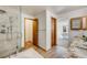 Bathroom featuring a walk-in shower and doorway leading into an ensuite bedroom at 10436 W 84Th Pl, Arvada, CO 80005