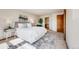 Bedroom showcasing a queen-sized bed, neutral decor, and an open doorway to the bathroom at 10436 W 84Th Pl, Arvada, CO 80005