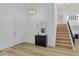 Bright entryway with a modern light fixture, wood-look floors, and staircase to the upper level at 1260 Ascot Ave, Highlands Ranch, CO 80126