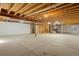 Spacious unfinished basement with concrete floor, open ceiling with exposed duct work, and support beams at 12447 W 77Th Ave, Arvada, CO 80005