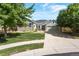 Charming home with manicured lawn, stone accents, mature trees, and a two car garage on a sunny day at 12447 W 77Th Ave, Arvada, CO 80005