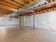 Unfinished basement with concrete floor, exposed beams, and large support beam at 4816 S Elk Way, Aurora, CO 80016
