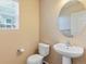 Simple half-bathroom featuring neutral walls, round mirror and pedestal sink at 4816 S Elk Way, Aurora, CO 80016