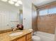 Cozy bathroom with tiled shower and tub combo, granite counters and a decorative mirror at 4816 S Elk Way, Aurora, CO 80016