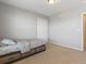 Bedroom featuring neutral carpet, a closet, bed with drawers, and bright, neutral colors at 4816 S Elk Way, Aurora, CO 80016