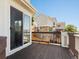 Private deck with wooden railing overlooking neighboring houses and blue skies at 4816 S Elk Way, Aurora, CO 80016