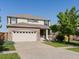 Charming two-story home with a brick facade, a well-maintained lawn, and a two-car garage at 4816 S Elk Way, Aurora, CO 80016