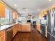 Open-concept kitchen with stainless appliances and a view of the living room fireplace at 4816 S Elk Way, Aurora, CO 80016