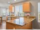 Bright kitchen featuring wooden cabinets, granite countertops, a stainless steel sink, and a large window at 4816 S Elk Way, Aurora, CO 80016